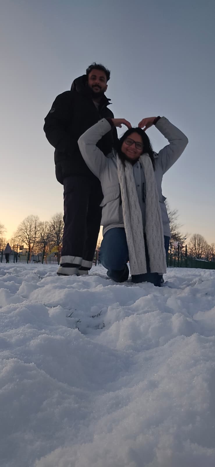 Making a heart in the snow at sunset