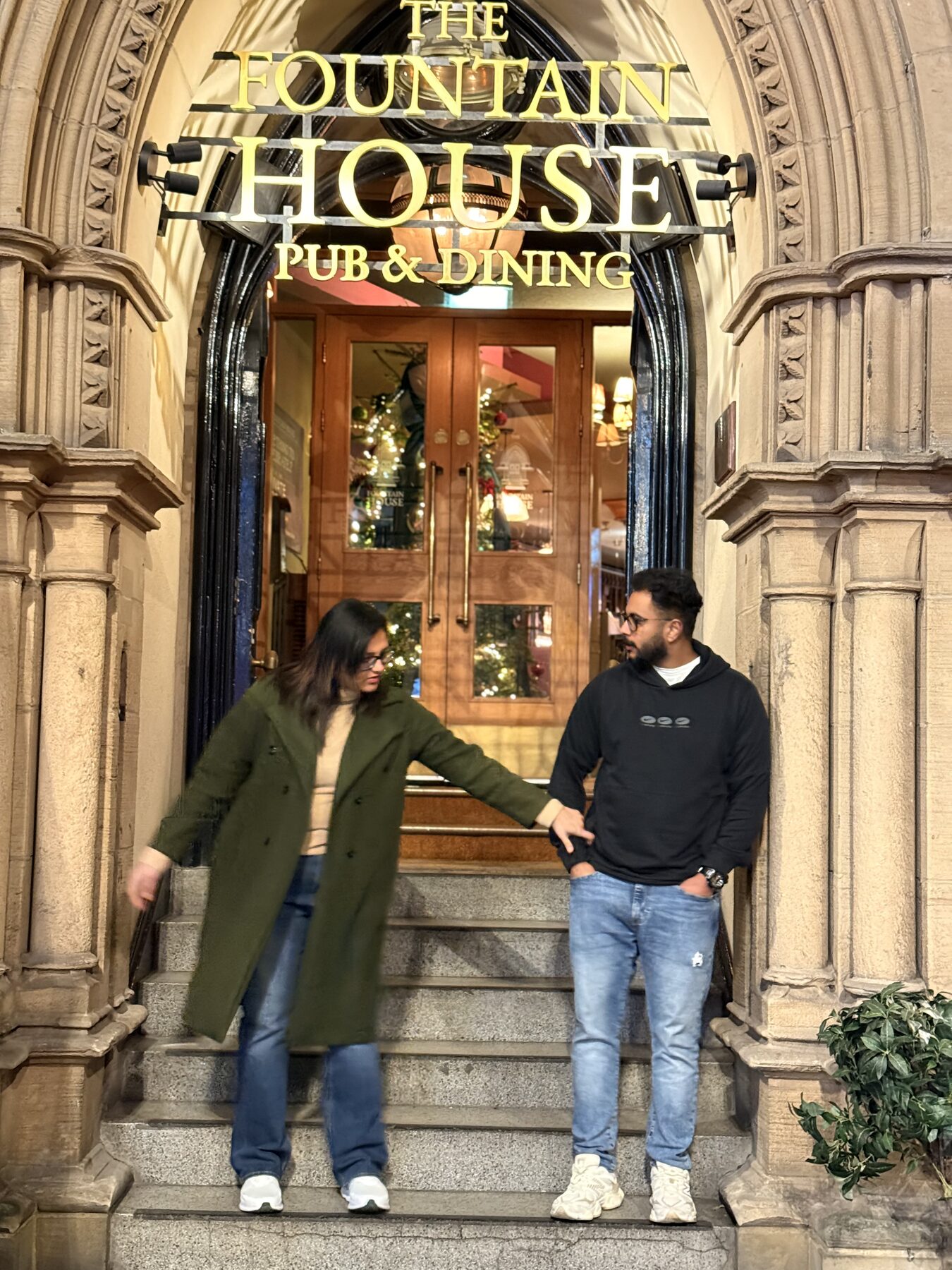 Holding hands under the arch at The Fountain House